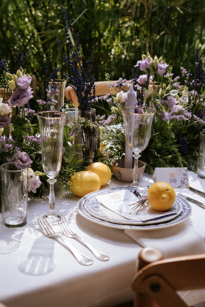 Mesa decorada con lavandas, limones, flores de temporada y vajilla azul inspirada en el estilo francés