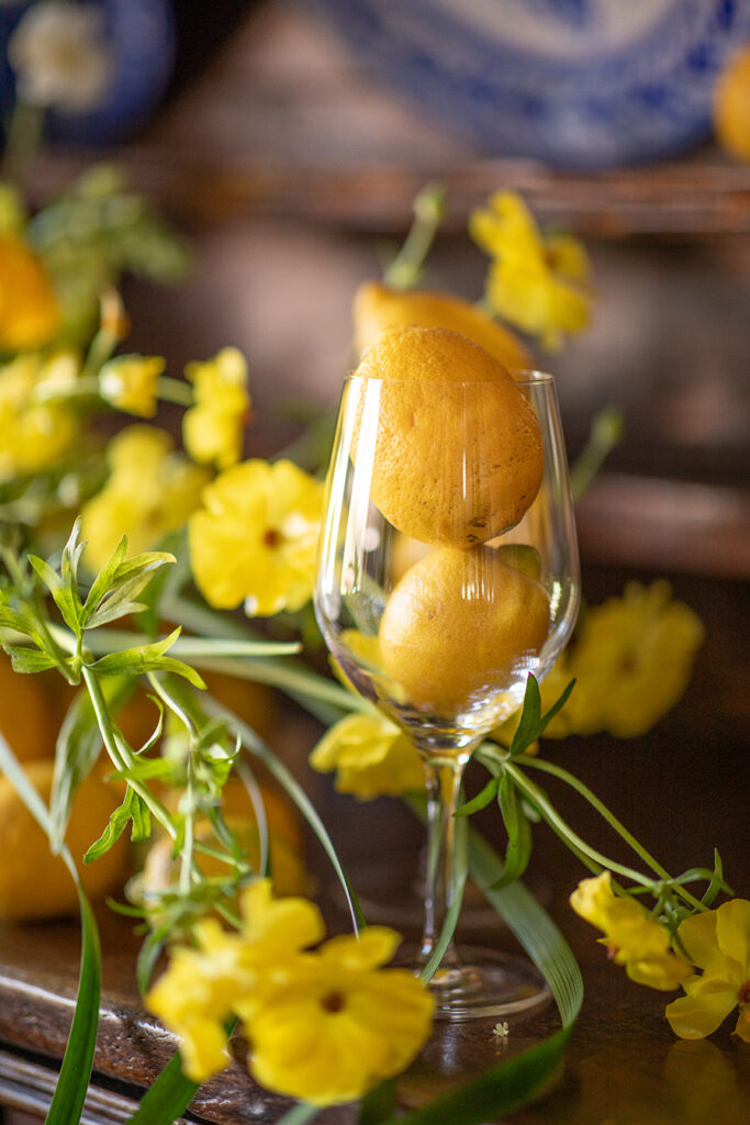 Bodegón floral con limones y ranúnculos butterfly para comedor de madera